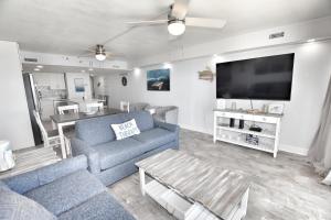 a living room with a couch and a flat screen tv at 0902 Waters Edge Resort condo in Myrtle Beach