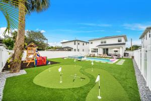 a backyard with a miniature golf course on the grass at Luxury Home w Heated Pool Gym Playground & More in Tampa
