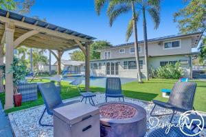 um pátio com cadeiras e um grelhador e uma casa em 8BR Family Resort with Pool and Playgrounds em Pompano Beach