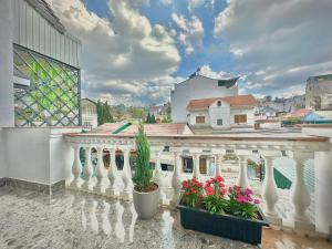 a balcony with flowers in pots on a building at Mon's House in Da Lat