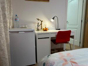 a bedroom with a desk and a red chair at Mirador 2 del mercado central habitación con baño privado in Valencia