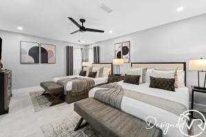 a bedroom with two beds and a ceiling fan at Charming 9BR New-Build Home w Heated Pool & Games in Hollywood