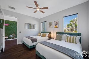 two beds in a room with a ceiling fan at Luxury Tampa Home w Pool Jacuzzi & Amenities in Tampa