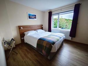 ein Schlafzimmer mit einem Bett und einem großen Fenster in der Unterkunft Mountain View Accommodation in Donegal