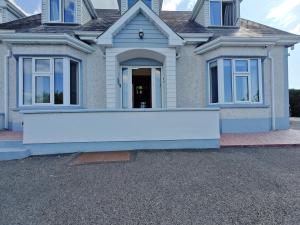 een huis met een grote witte muur ervoor bij Mountain View Accommodation in Donegal