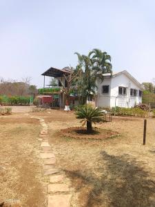 ein Haus mit einer Palme vor einem Hof in der Unterkunft OTE Dulis Den in Pune