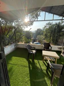 a patio with chairs and a table and grass at OTE Dulis Den in Pune