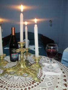 a table with two candles and a glass of wine at Inca´s Suite in Los Baños del Inca