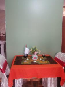 a table with a red table cloth and two glasses of wine at Inca´s Suite in Los Baños del Inca