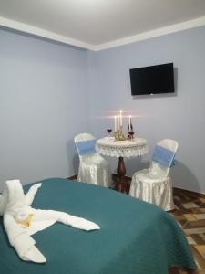 Zimmer mit einem Bett und einem Tisch mit 2 Stühlen in der Unterkunft Inca´s Suite in Los Baños del Inca