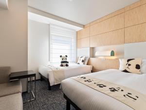 Mitsui Garden Hotel Ueno - Tokyo Reopened in July 2023 في طوكيو: غرفه فندقيه سريرين عليها دب باندا