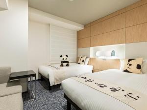 Mitsui Garden Hotel Ueno - Tokyo Reopened in July 2023 في طوكيو: غرفه فندقيه سريرين عليها دب باندا