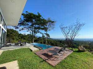 una casa con piscina y una silla en el césped en Villa Luz en Villavicencio