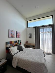 a bedroom with a bed and a large window at Villa Luz in Villavicencio