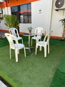 eine Gruppe Stühle und ein Tisch auf Gras in der Unterkunft HOSTAL LAS GARZAS in Talara