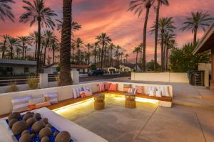 a patio with a couch and palm trees at sunset at Roma by AvantStay Stylish Oasis w Private Pool in Phoenix