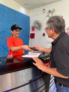 un hombre y una mujer parados en una caja registradora en HOSTAL LAS GARZAS, en Talara