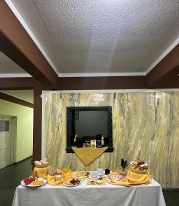 einen Tisch mit Teller mit Lebensmitteln und einem Spiegel in der Unterkunft HOSTAL LAS GARZAS in Talara