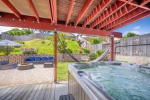 a hot tub in a backyard with a swing at Sweetwater by AvantStay Yard w Hottub Firepit in Bonita