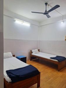 two beds in a room with a ceiling fan at MAYUR HOTEL in Dimāpur