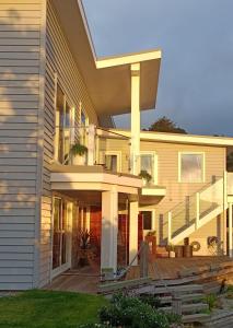 a large house with a porch and a deck at Luxurious waterfront accommodation in Dunedin