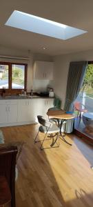 Luxurious waterfront accommodation في دنيدن: مطبخ مع طاولة وكراسي في غرفة