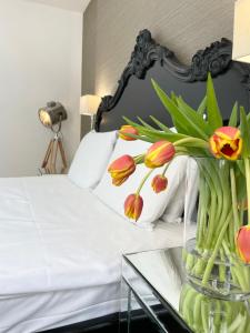 um quarto com uma cama com um vaso de flores numa mesa de vidro em Luxury Apartments in Westminster em Londres