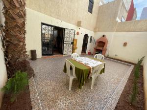 een patio met een tafel en stoelen in een gebouw bij Mini villa duplex in Agadir