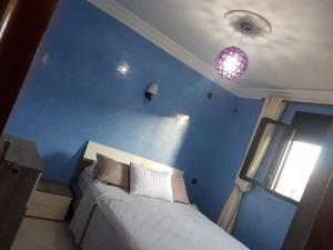 a blue bedroom with a bed and a window at Mini villa duplex in Agadir