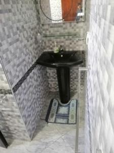 een kleine badkamer met een wastafel en een spiegel bij Mini villa duplex in Agadir