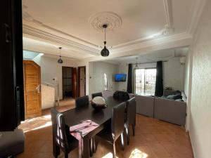 een woonkamer met een eettafel en een bank bij Mini villa duplex in Agadir