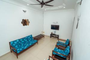 sala de estar con sofá azul y sillas en GLYSM Tambun Stay "Pura Vida", en Tambun