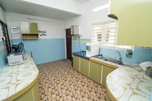 uma cozinha com duas mesas e um lavatório em GLYSM Tambun Stay "Pura Vida" em Tambun