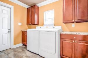 a kitchen with a white sink and wooden cabinets at Domain on Dumaine in New Orleans