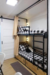 2 łóżka piętrowe w pokoju z drzwiami w obiekcie Dani's House Pod Coron w mieście Coron