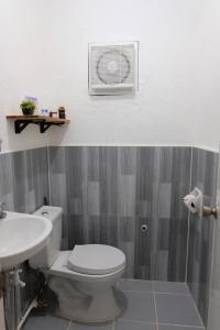 uma casa de banho com um WC branco e um lavatório. em Dani's House Pod Coron em Coron
