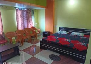 een slaapkamer met een bed en stoelen erin bij Hotel M.K. Palace in Gaya