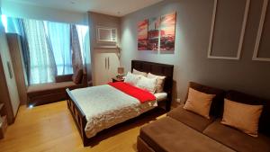 um quarto com uma cama e um sofá em Bright Comfy Room w/WiFi near Makati/Manila/Philippines em Manila
