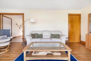 uma sala de estar com um sofá branco e uma mesa de vidro em 3BR Boone Lakefront home em Piney Flats