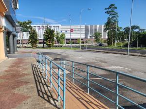 an empty street with a fence in front of a building at BEAR HOTEL at NILAI in Nilai
