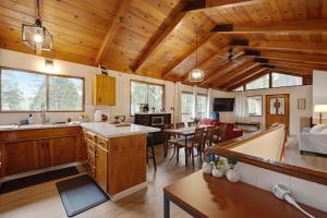 an open kitchen and living room with wooden ceilings at Álaínn Cabin in the trees in Twain Harte
