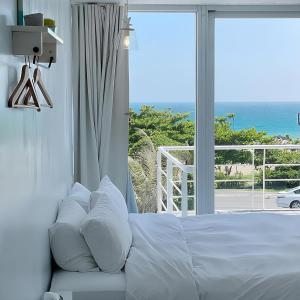 een slaapkamer met een bed en uitzicht op de oceaan bij We Stay Inn in Eluan