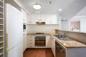 a white kitchen with a sink and a stove at Riverview 2B2B apt in CBD w/parking, pool, gym in Brisbane