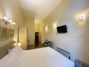 a bedroom with a bed and a flat screen tv at Grand Central Serviced Apartments in Auckland