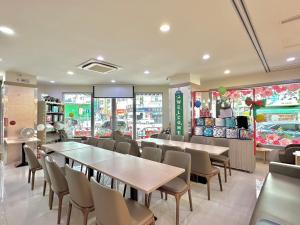 um restaurante com mesas e cadeiras e uma loja em Mei Hotel em Taichung