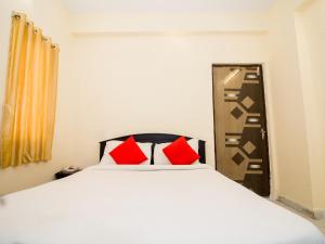 a bedroom with a large white bed with red pillows at Pearl Suites - Located at a strategic location where Srinivasa Sethu Flyover starts and only hotel in the area to have a very spacious car parking - Skip city traffic to reach Main Temples and Airport - AC Rooms, Family Suites, Fast WiFi in Tirupati