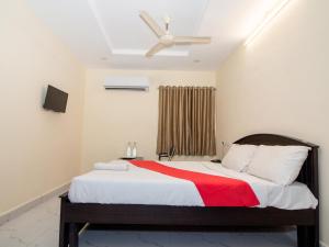 una camera con un letto con una coperta rossa di Pearl Suites - Located at a strategic location where Srinivasa Sethu Flyover starts and only hotel in the area to have a very spacious car parking - Skip city traffic to reach Main Temples and Airport - AC Rooms, Family Suites, Fast WiFi a Tirupati