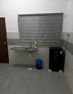 a bathroom with a sink and a blue trash can at Bahau ioi homestay in Bahau