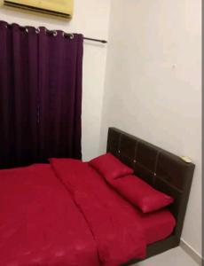 a bedroom with a red bed with a curtain at Bahau ioi homestay in Bahau