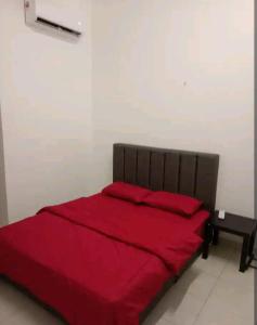 a bedroom with a red bed with a red blanket at Bahau ioi homestay in Bahau